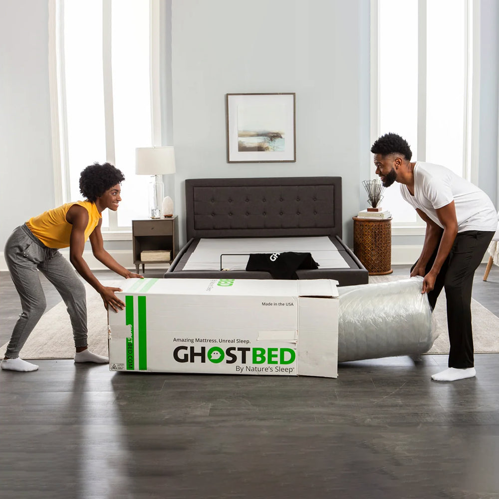 Easy unboxing and setup process of a GhostBed mattress-in-a-box being pulled from its shipping carton in a modern bedroom.
