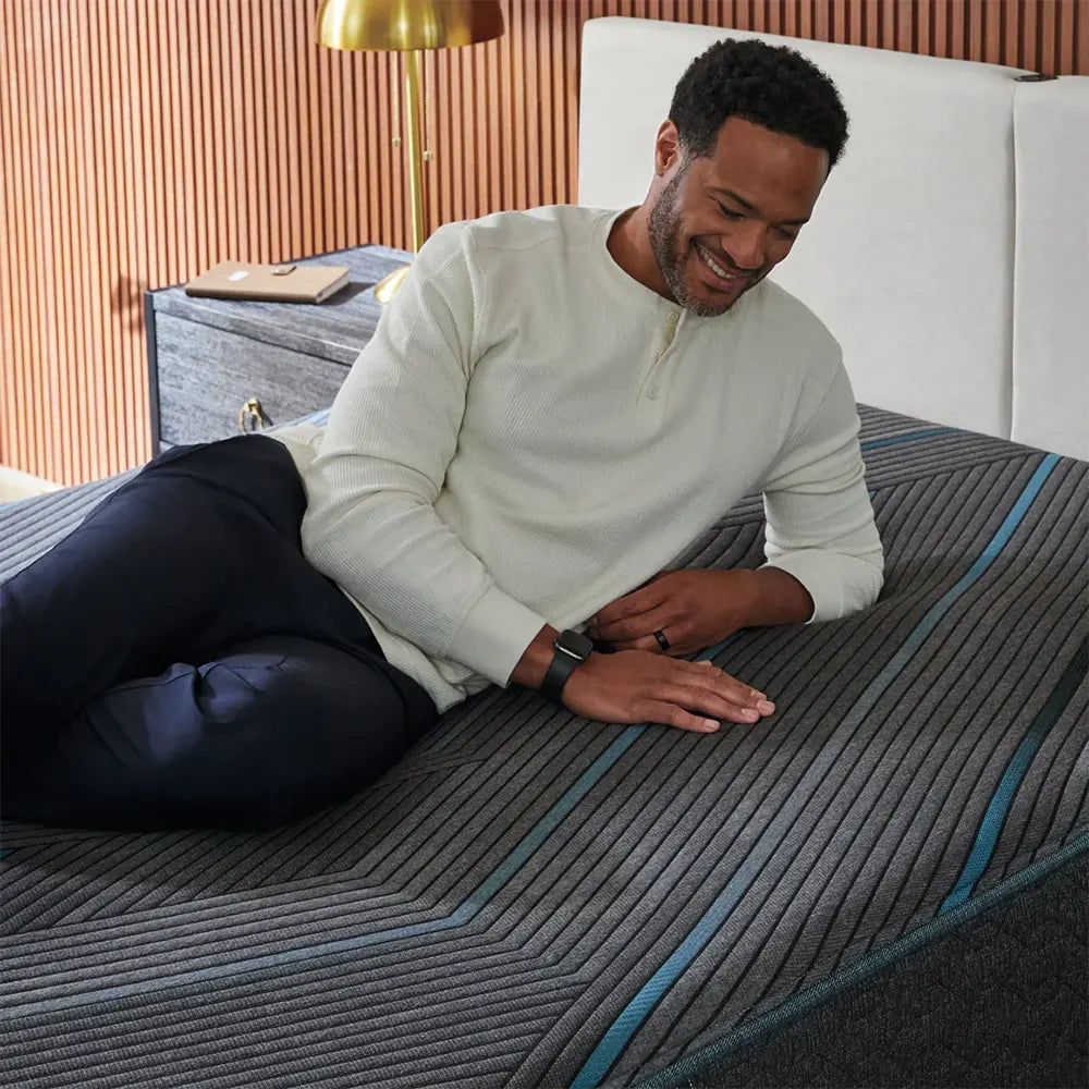 Man relaxing on a Simmons Beautyrest Hybrid 12" Medium Firm Mattress with contouring comfort.
