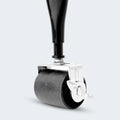 Durable rug roller wheel on a Malouf metal bed frame leg for easy mobility and floor protection.

