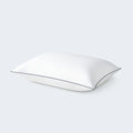 SleepTone Loft feather and down pillow side view showing its plush loft and elegant navy piped edges.
