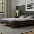 Three-quarter angle of the Essentials 10-inch firm memory foam mattress by South Bay, showcasing the light grey quilted top and charcoal side panels.
