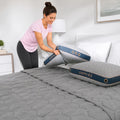 A woman placing a Cosmo 2.0 cooling pillow on a bed, highlighting the breathable moisture-wicking cover.