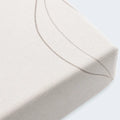 Close-up of the breathable, soft organic cotton fabric and durable corner of the fitted crib sheet.
