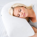 Side sleeper resting on a Malouf L-shape pillow for spinal alignment and shoulder pressure relief.

