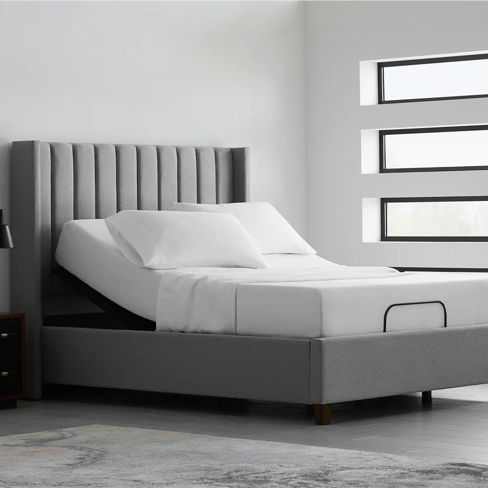 Single Malouf E255 adjustable bed base with a mattress shown in a head-up position within a contemporary bedroom setting.
