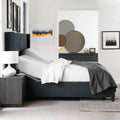 Side view of the Malouf S755 power base with head section elevated, shown with a mattress and white bedding in a contemporary room.
