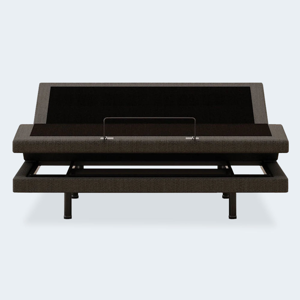 Front view of the Comfort Ultra Adjustable Base by Ashley with the head elevated, highlighting the mattress retainer bar and upholstered frame.
