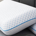Stacked Malouf Hyperchill pillows showing the textured quilted cooling pattern and teal piped edges.
