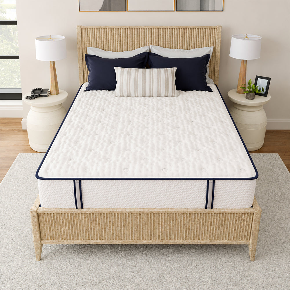 High-angle bedroom shot of the Sofinity Hybrid Signature firm mattress showcasing the wide sleep surface on a natural wood bed frame.
