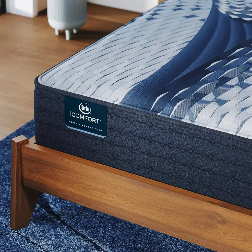 Close-up of the Serta iComfort Aspire logo on a navy blue quilted mattress border with cooling technology.
