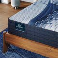 Close-up of the Serta iComfort Aspire logo on a navy blue quilted mattress border with cooling technology.
