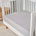 Close-up of a grey Hyper-Linen performance crib sheet providing a smooth, breathable sleeping surface.
