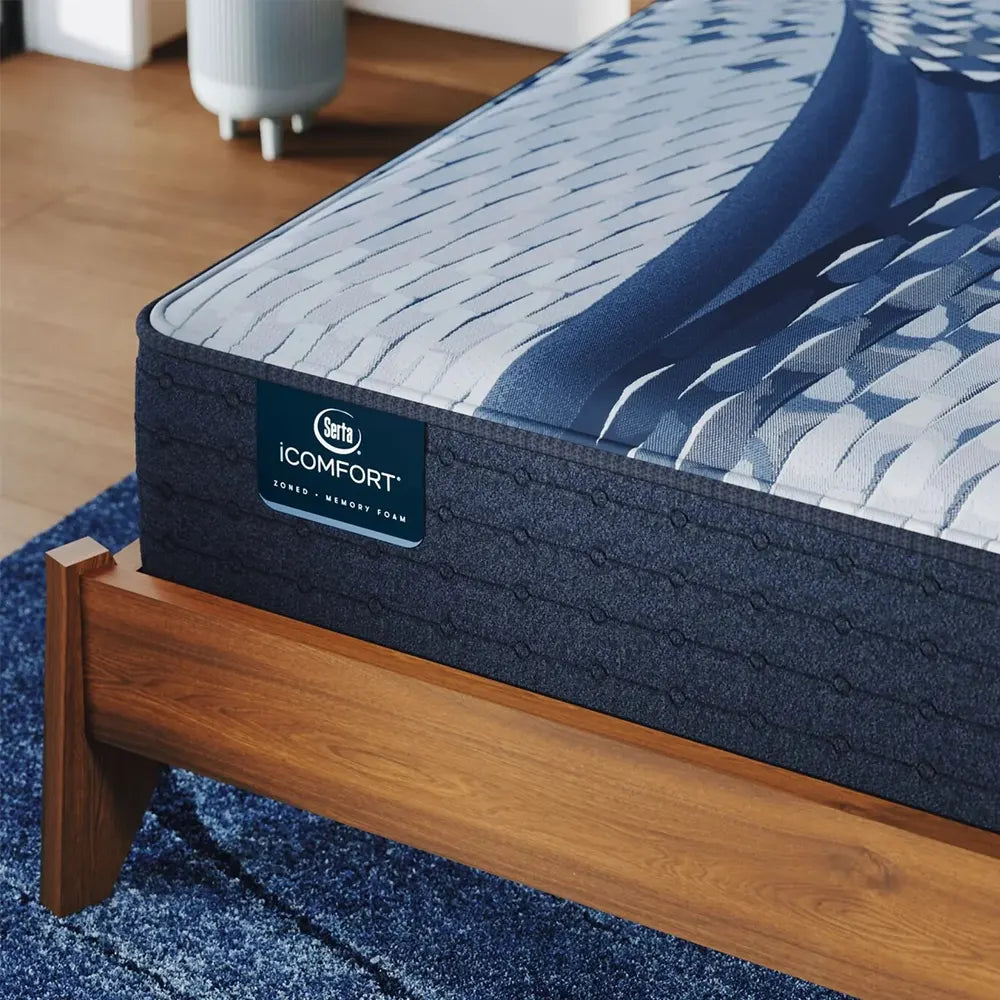 Close-up of Serta iComfort Iona branding on a navy blue quilted mattress panel with cooling fabric.
