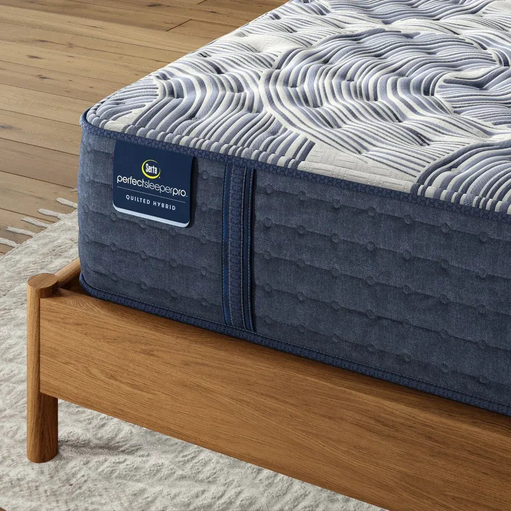 Close-up of Serta Perfect Sleeper Pro quilted hybrid mattress corner showing the 14 inch medium profile texture.
