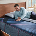 Man resting on Beautyrest Hybrid Level Three Firm mattress surface for targeted pressure relief.
