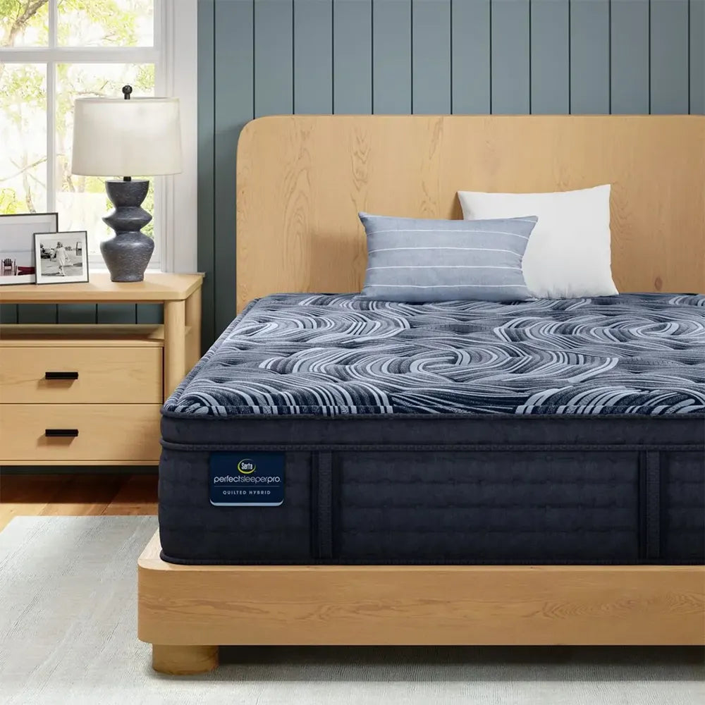 Close-up of Serta Perfect Sleeper Pro plush pillow top mattress showing navy quilted pattern and branding.
