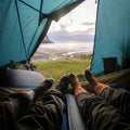 BEDGEAR Flow Travel Pillow inside a camping tent with a scenic beach view for comfortable outdoor sleeping.
