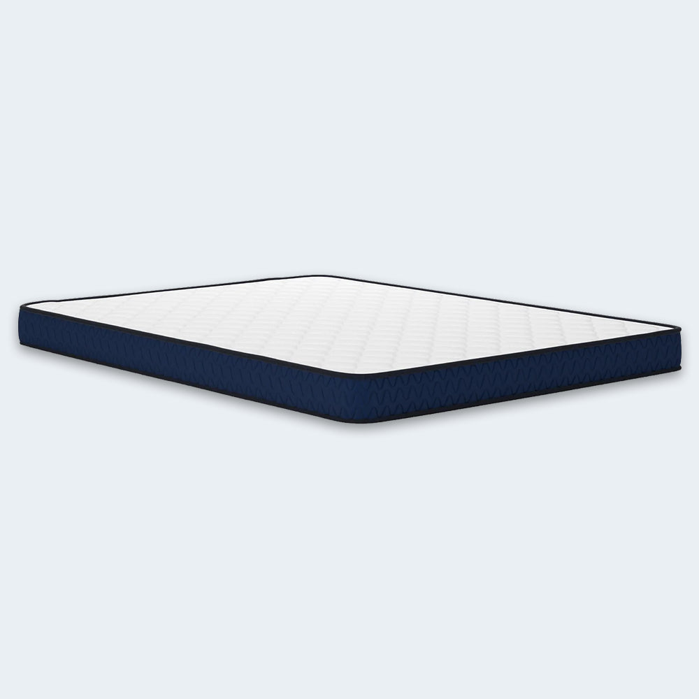 Perspective studio shot of the Ashley Firm 6-inch low-profile mattress showcasing the durable quilted top and reinforced navy border