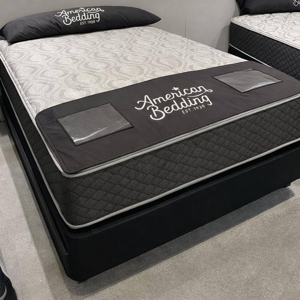 American Bedding Baird 14-inch flippable hybrid mattress on display, showcasing the premium build and two-sided comfort technology.
