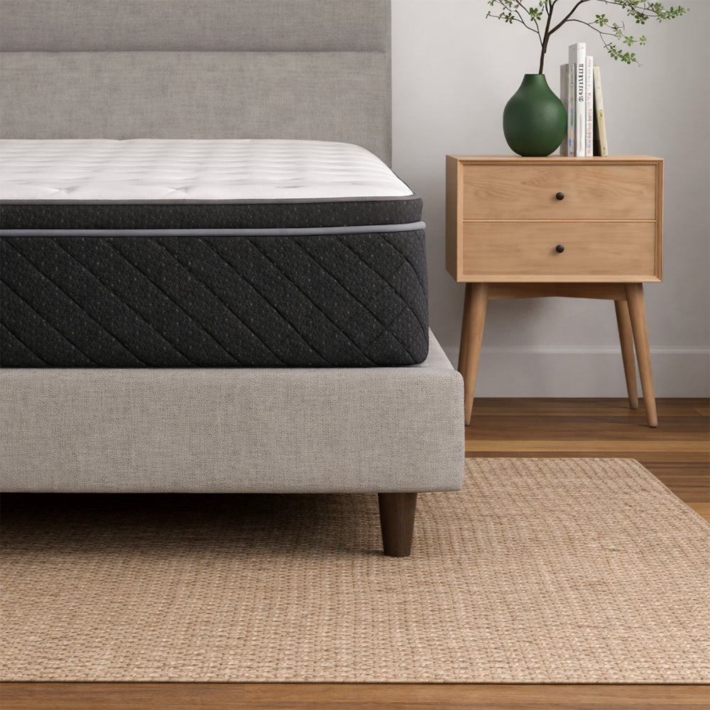 American Bedding Griffin 14-inch Hybrid Plush Mattress styled in a modern bedroom on a grey upholstered platform bed frame with contemporary decor.
