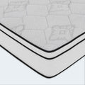 Detailed corner shot of the American Bedding Cymbal Jingle 10-inch mattress featuring a white quilted surface and black piped edges.
