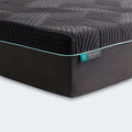 Close-up corner of the Ice Cloud Coolsync Hybrid Mattress showing a textured dark cover and teal piping.