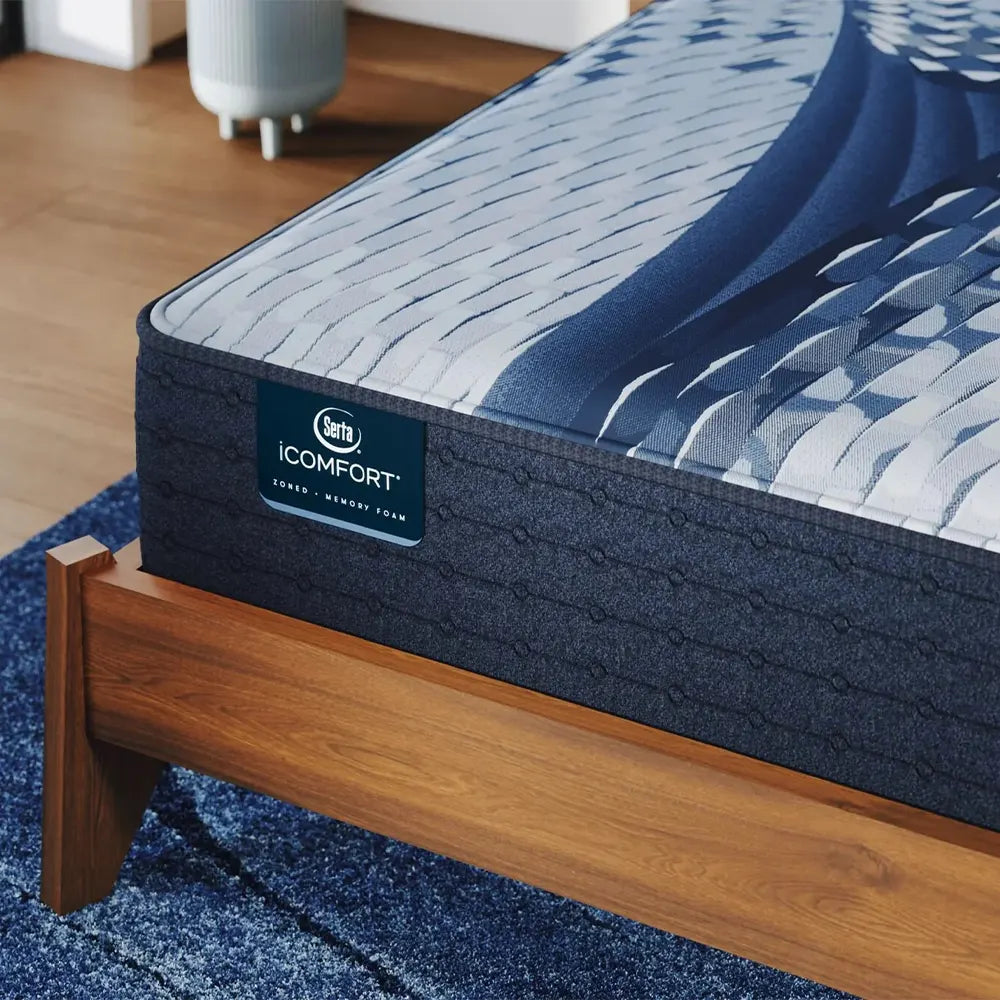 Close-up of Serta iComfort Aspire branding on the navy blue quilted mattress border with cooling technology.
