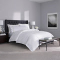 Luxury white duvet and sheet set with silver double-stripe embroidery for a sophisticated bedroom look.
