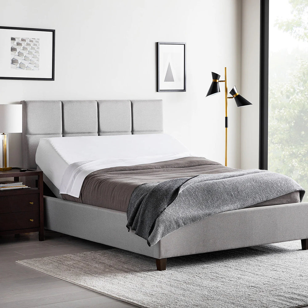 Fully made bed featuring the Malouf M555 adjustable base in a head-up position for comfortable reading or anti-snore relief.
