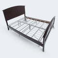 Heavy-duty Malouf metal platform base used as a mattress foundation inside a traditional wooden bed frame.
