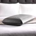 Breathable Malouf charcoal memory foam pillow with zoned ventilation holes for temperature regulation.
