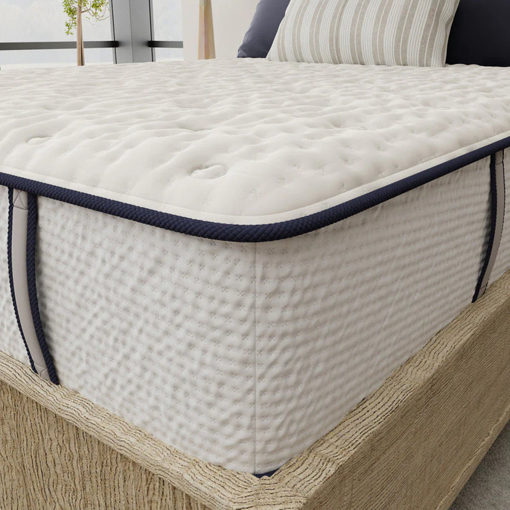 Close-up detail of the Sofinity foam mattress quilted top with premium navy blue edge piping and breathable side fabric.
