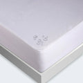 Close-up of waterproof BEDGEAR iProtect mattress protector showing liquid beads on a stain-resistant surface.
