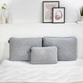 Three sizes of gray BEDGEAR Flow Performance pillows stacked on a bed showing different loft options.
