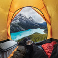 BEDGEAR Storm travel pillow inside a camping tent with a scenic view of mountains and a blue alpine lake.
