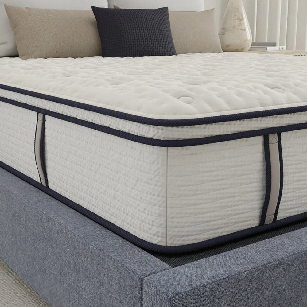 Close-up detail of the Sofinity Hybrid Signature Euro top mattress showcasing the high-quality stitching, breathable side fabric, and blue accent trim.
