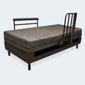 Flat profile of the Customatic Independence bed featuring a high-safety side rail and modern textured fabric.
