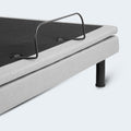 Close-up of the durable metal mattress retainer bar at the foot of the upholstered Malouf S755 adjustable bed foundation.
