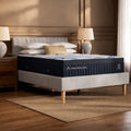 Modern bedroom setting featuring the DreamCloud Premier 13-inch Hybrid Mattress styled on a minimalist grey upholstered platform bed frame.
