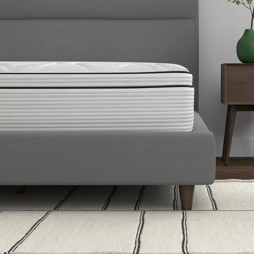 Close-up side view of the American Bedding Cymbal Jingle 10-inch firm mattress illustrating the thick Euro top comfort layer and striped side panels.
