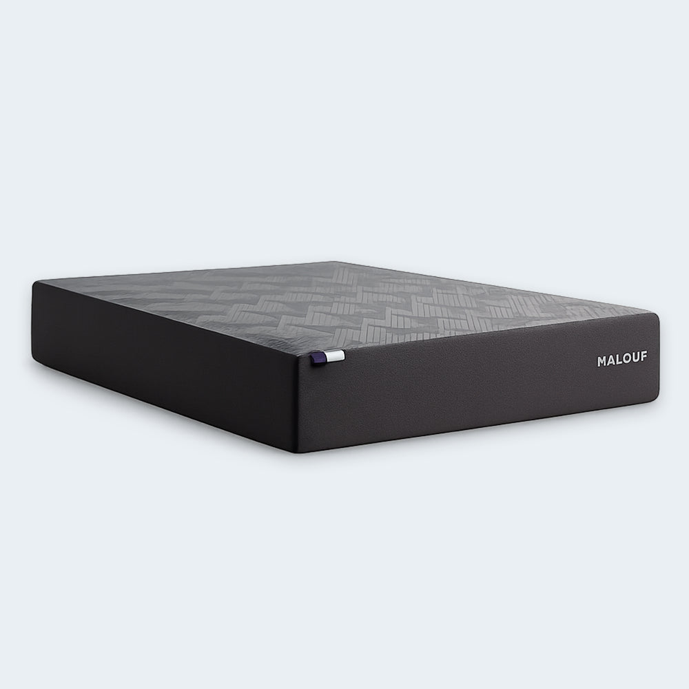 Isolated angled profile of the Malouf Neve 12-inch all-foam mattress showcasing its high-profile design and breathable grey geometric cover.

