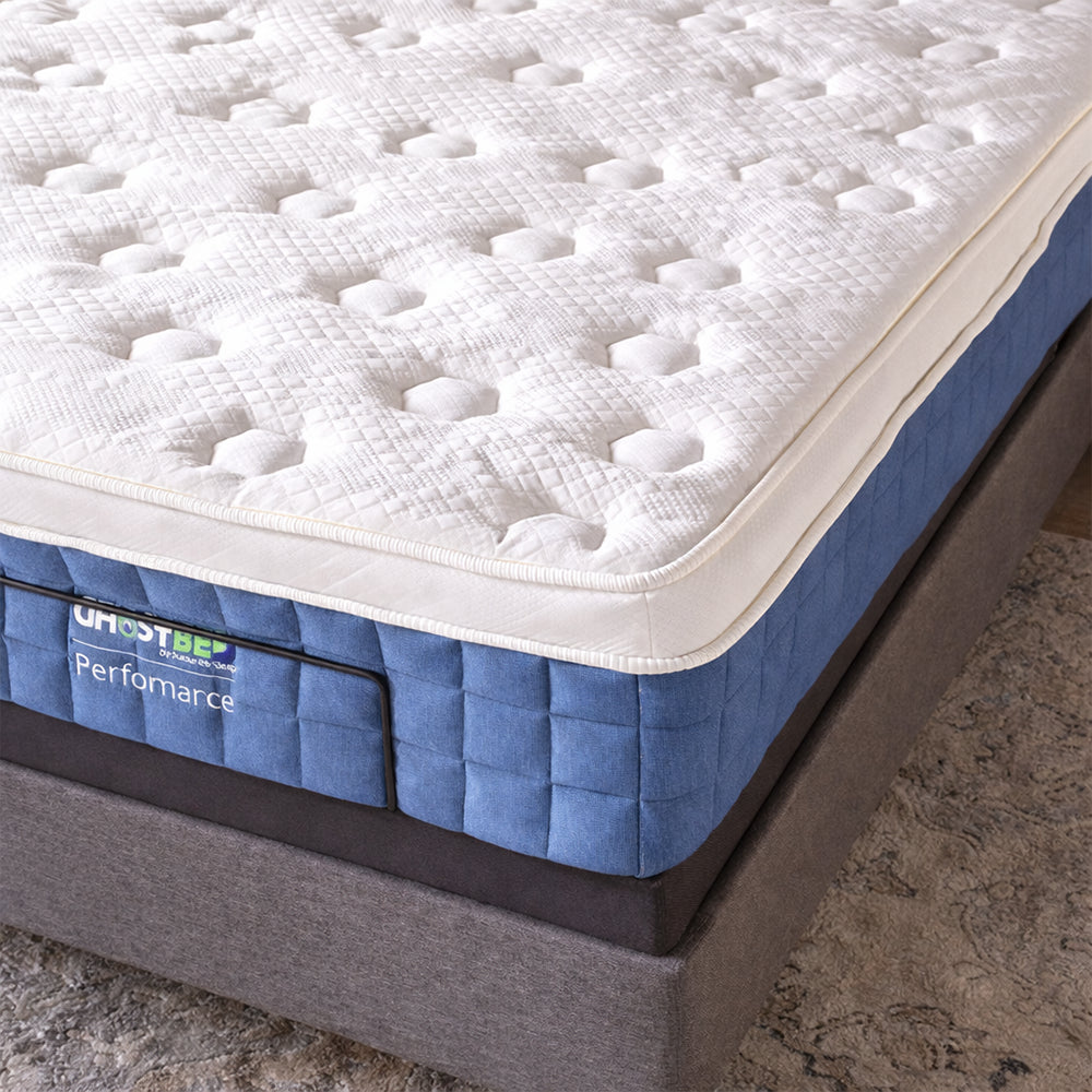 Detailed profile view of the GhostBed Performance hybrid mattress side panel featuring premium blue quilted fabric and reinforced edge support.
