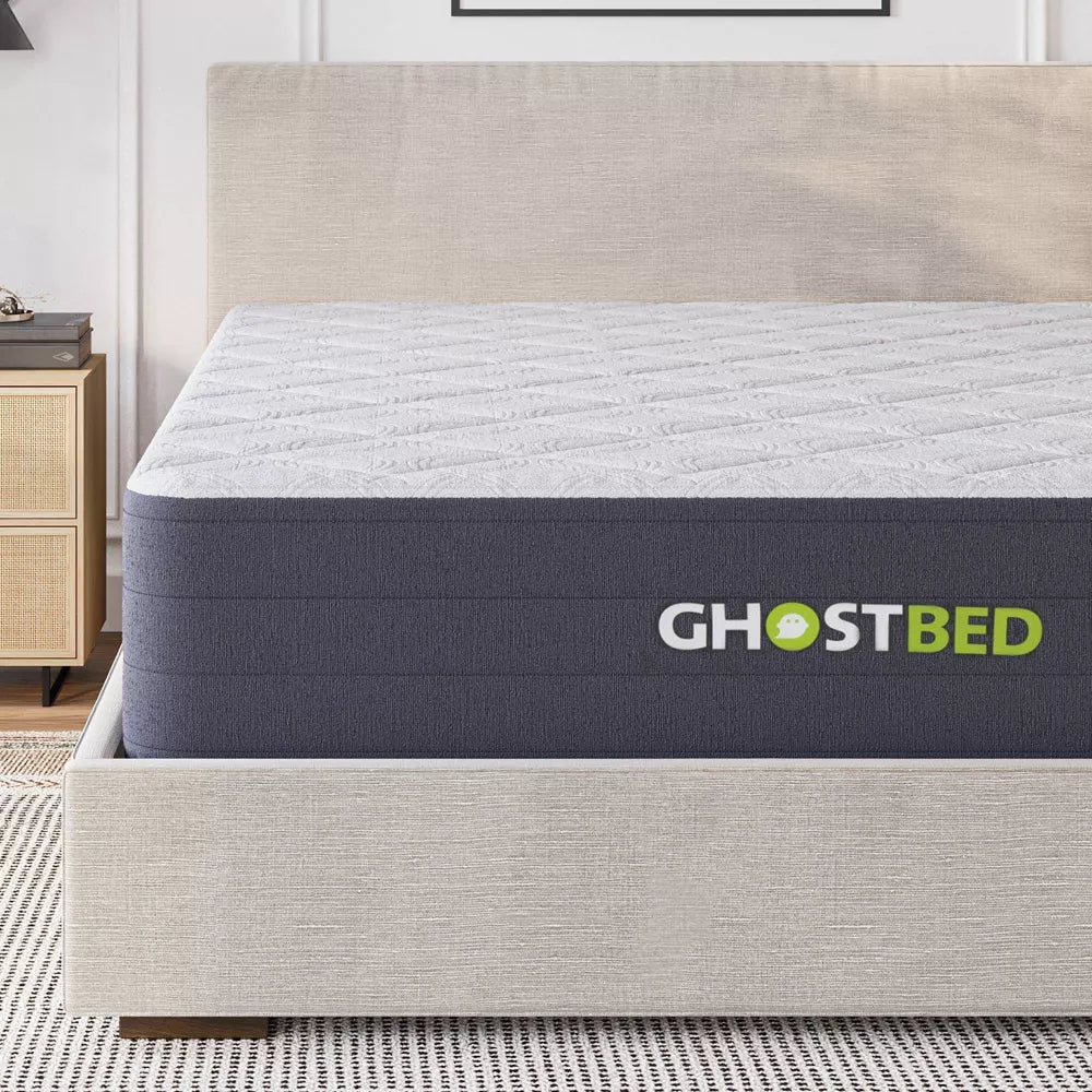Close-up of the GhostBed Hybrid Mattress side panel and logo, highlighting the premium grey fabric and plush 12-inch profile on a platform bed.
