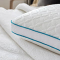 Close-up of teal piping and breathable quilted fabric on a Malouf HyperChill hybrid cooling pillow.
