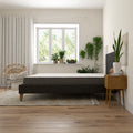 Side view of the Daisy 8-inch firm mattress by South Bay on a low-profile bed frame in a bright, modern bedroom with indoor plants.
