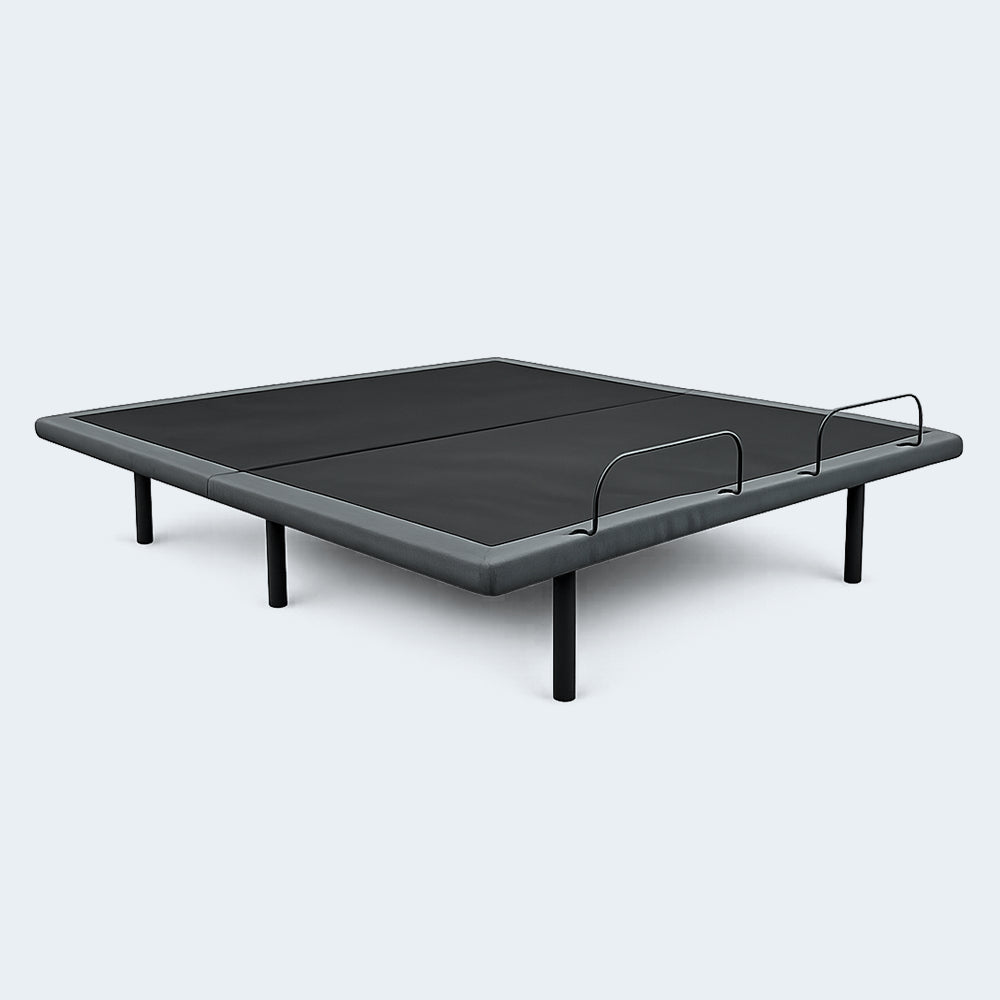 Customatic Dreamsense Synergy adjustable bed base in a flat position showing the upholstered frame and steel legs.

