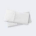 Stacked white pillows in BEDGEAR Hyper-Linen cases, featuring a breathable linen-blend for maximum airflow.
