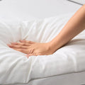Hand pressing into a soft Malouf Gel Convolution pillow, showcasing its responsive down-like comfort.
