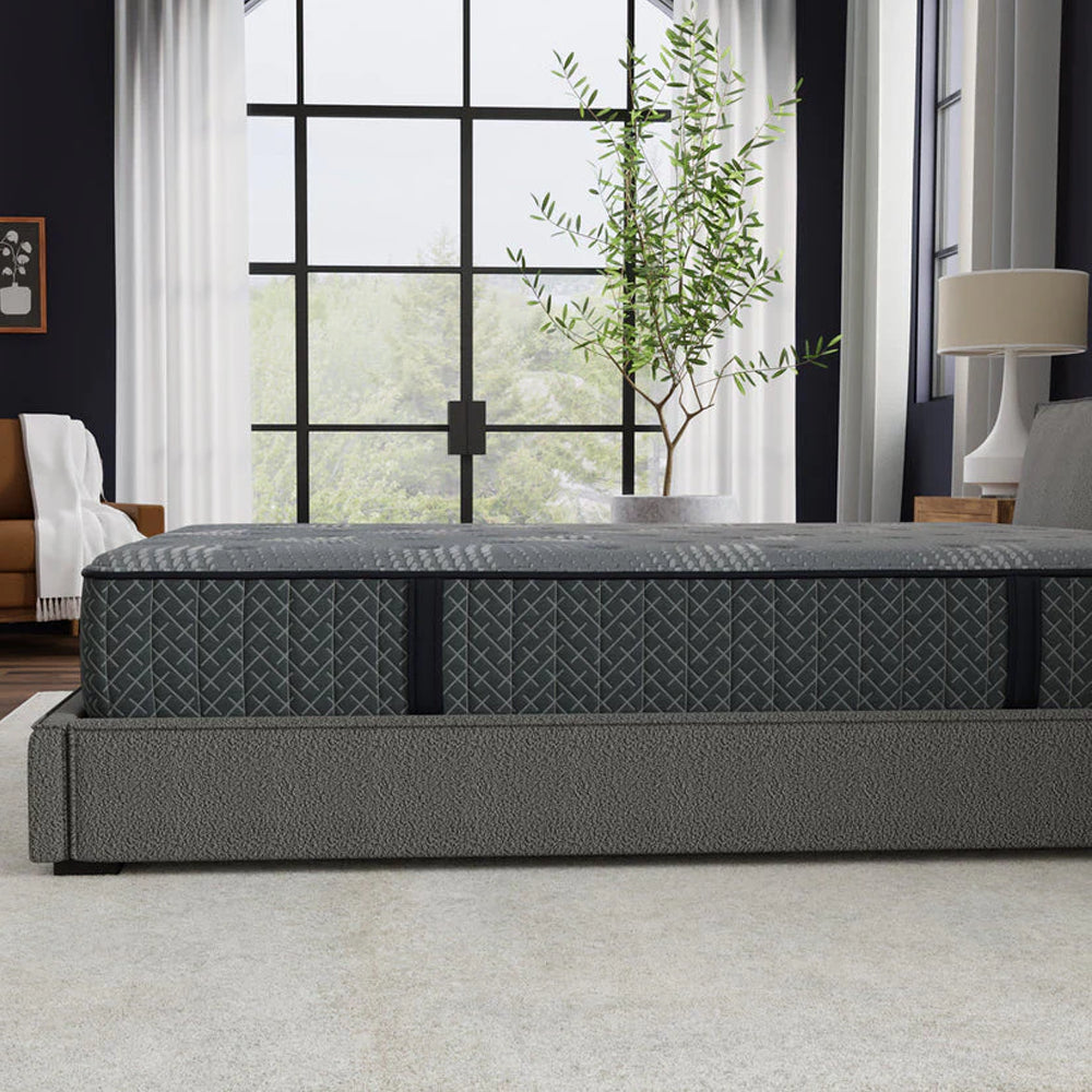Side profile of the 10-inch thick Allureluxe™ hybrid mattress in a modern master bedroom, illustrating its sleek design and supportive foam encasement.
