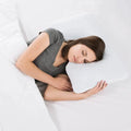 Side sleeper resting on a Malouf shoulder cutout pillow for ergonomic neck alignment and pressure relief.